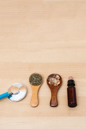 A closeup of Herbal medicine in spoon on wooden background.