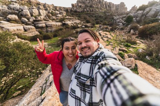 A beautiful shot of a Caucasian couple taking a selfie on a sunny day in El Torcal de Antequera, Malaga, Spain
