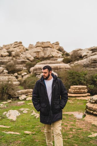 A Vertical shot of an adult Caucasian man walking in El Torcal de Antequera during daytime, Malaga, Spain