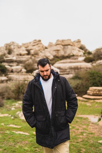 A close-up shot of an adult Caucasian man walking in El Torcal de Antequera during daytime, Malaga, Spain
