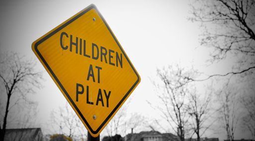 A closeup shot of a yellow children at play sign in a park