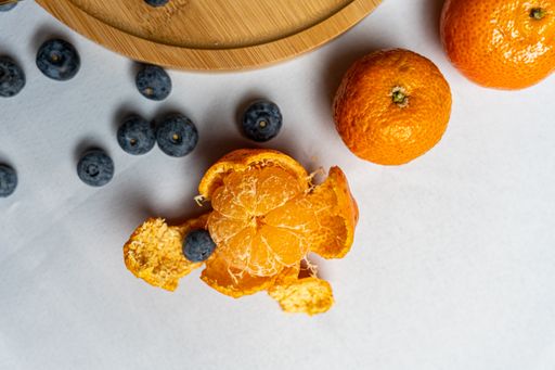 A top view of blueberries and mandarins on a white background