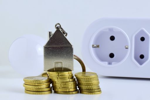Closeup shot of golden coins and electrical outlet on a white background