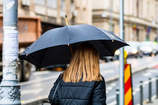A female with an umbrella on the street on a rainy day in Bucharest, Romania