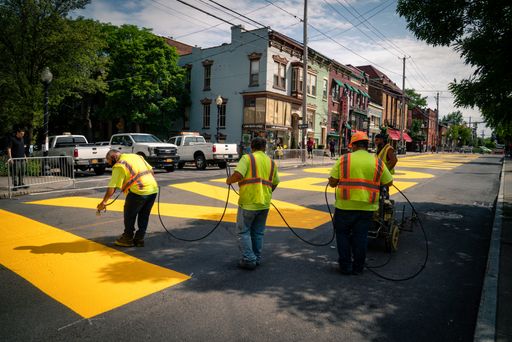 Workers paint a massive Black Lives Matter sign on Lark street in downtown Albany, New York