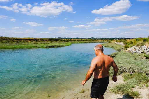 A view of a man going to swim in the river in Guerande
