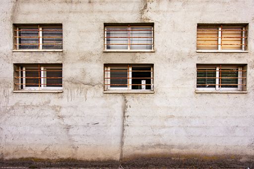 The small windows with lattices on the facade of an old abandoned building