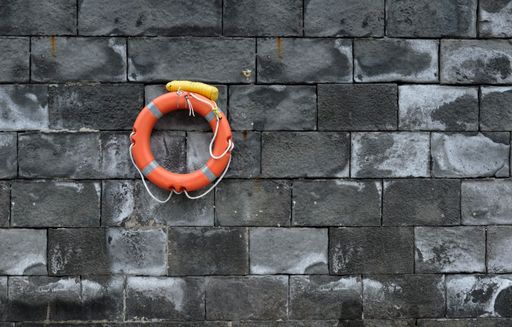 An orange lifebuoy hanging in a wall
