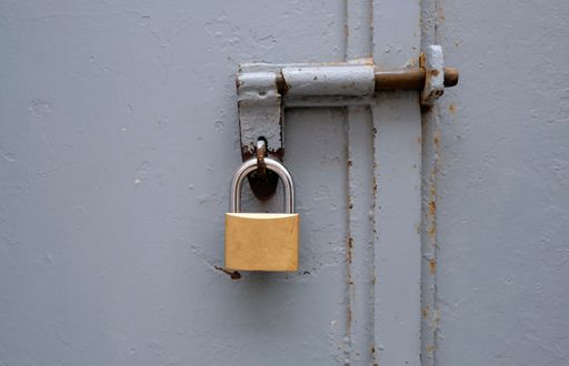 A closeup shot of the padlock on gray gates