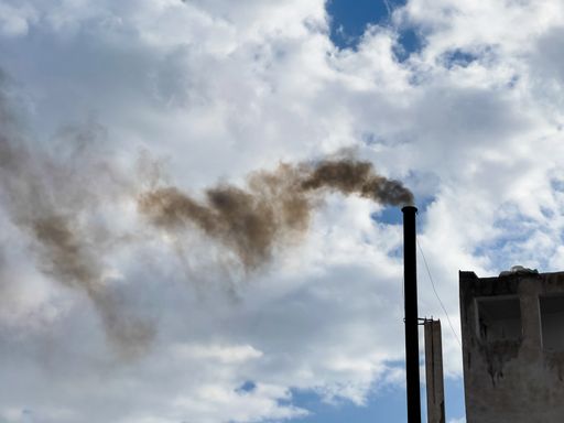 Smoke from a pipe on a background of a cloudy sky