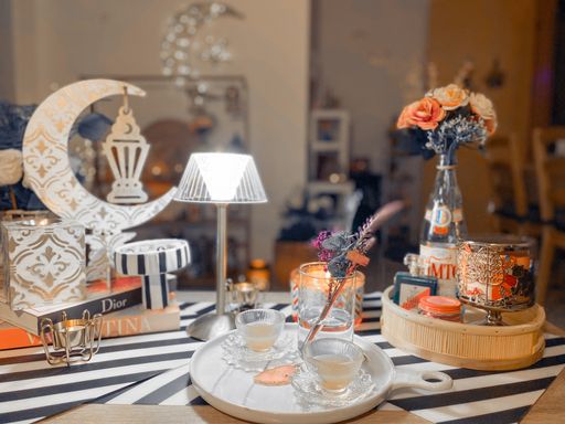 A nicely decorated table with tea cups, flowers and candle