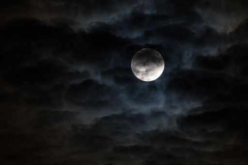 A beautiful shot of a full moon in a cloudy sky-paranormal concept