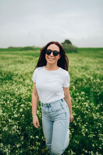 A cheerful young Caucasian lady from Spain in a meadow of flowers