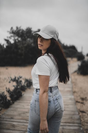 A portrait of a female Caucasian walking on a wooden pathway and looking back