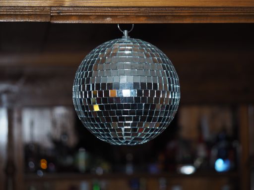 A disco ball with a bar in the background