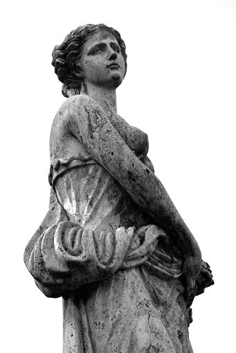 A low angle grayscale shot of a woman sculpture on isolated white background