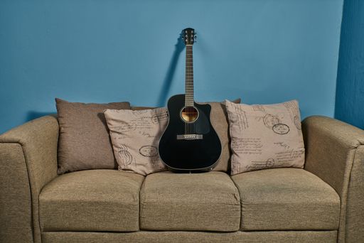 Acoustic Guitar on an armchair ready to start playing