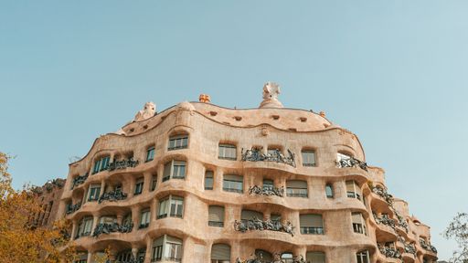 a low angle shot of the La Pedrera building from the street