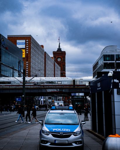 A vertical shot of Berlin City Tower,Street Train and a police car in the street