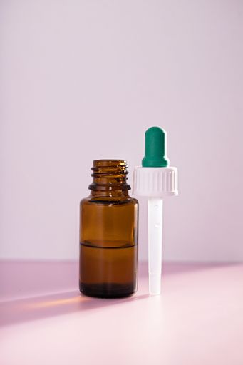 A closeup of medicine bottle and dropper over a white background. Vaccine, medicine, protection, COVID19, coronavirus concept