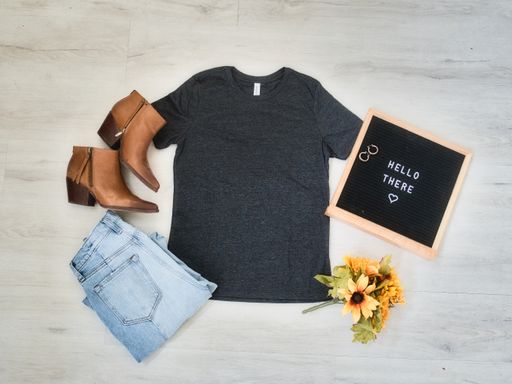 A top view shot of a black t-shirt, jeans, and a pair of brown leather ankle boots