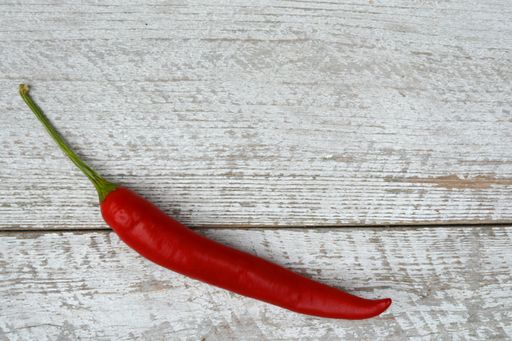 A high angle shot of red hot chili pepper on a wooden surface