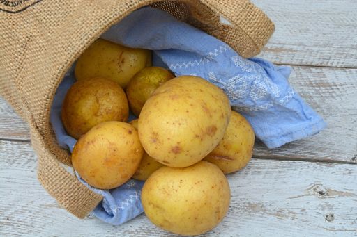 A closeup shot of a bag of potatoes on a wooden surface