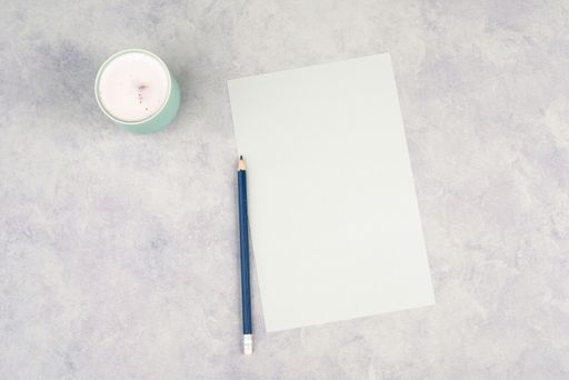 Empty paper with a pen and a cup of coffee, textured background, brainstorming for new ideas, writing a message, taking a break, home office desk