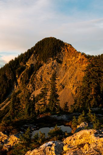 A beautiful view of mountain landscapes against a cloudy sky at sunset