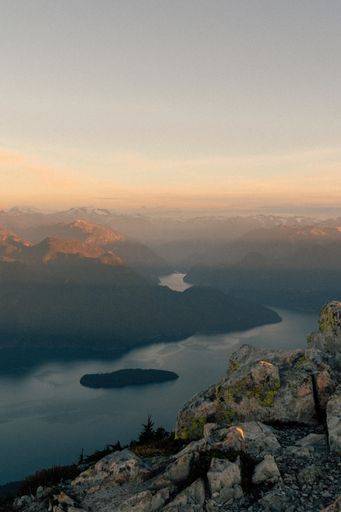 A scenic shot of mountains along a river during sunrise