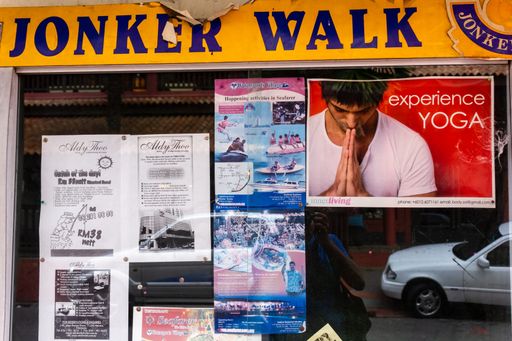 Melaka, Malaysia - October 2012: Posters advertising Yoga and tourist activities on a wall on Jonker Walk at Jonker street in the old town of Malacca.