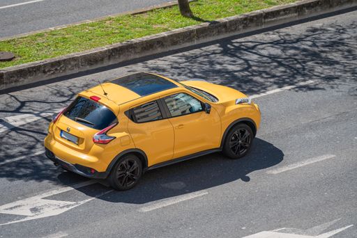 A photo of a yellow Nissan Juke SUV Coupe car on the streets of Lisbon