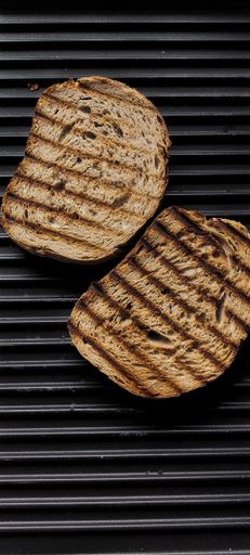 A top view of two pieces of grilled brown toasts on the grill