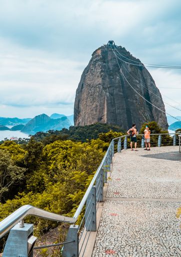 A vertical shot of tourists at Morro da Urca station with Sugarloaf Mountain in the background, Rio de Janeiro, Brazil