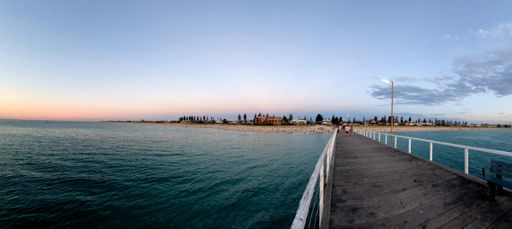A panoramic shot of the calm sea captured from a bridge on a clear day