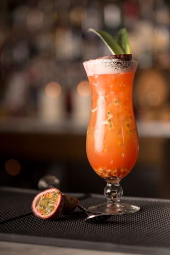 A vertical shot of glass of passion fruit cocktail on table