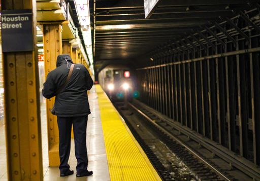 a beautiful shot of a man waiting the metro in New York City Subway