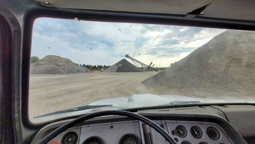 A point of view shot from the driver's side of an old truck at a query driving to pick up gravel