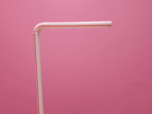A view of white and red plastic straw isolated on pink background