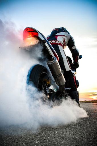 A vertical shot of a motorcycle tearing its tire apart