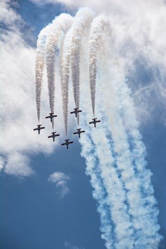 A vertical shot of the beautiful Spain Airforce Show with smoke traces on their back in a blue sky