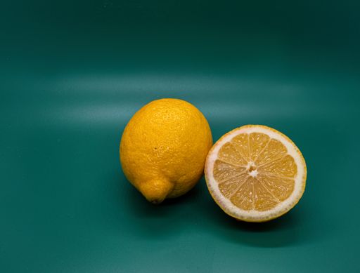 A closeup shot of two lemons in a studio on a green background
