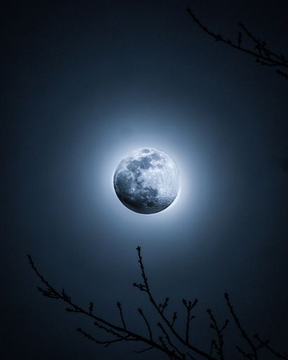 The bright full moon in the dark black sky captured at night