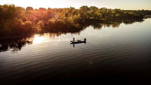 An aerial view of a fisherman with a fishing boat in the middle of the lake Grand, Oklahoma at sunset