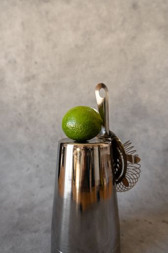 A Vertical shot of fresh lime on steel shaker.