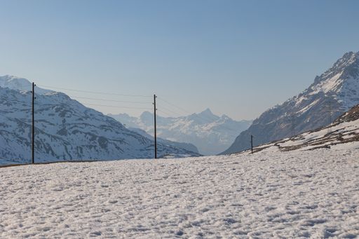 The landscape of a mountain valley covered with snow and the road passing through them