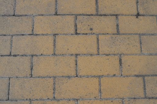 A high angle shot of a yellow-tiled dirty surface
