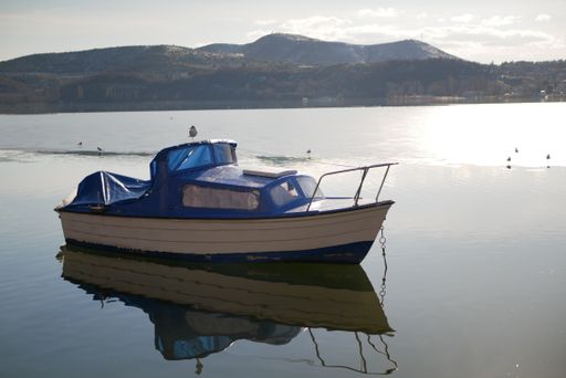 An Old fishing boat reflected on a lake in city of Kastoria, Greece