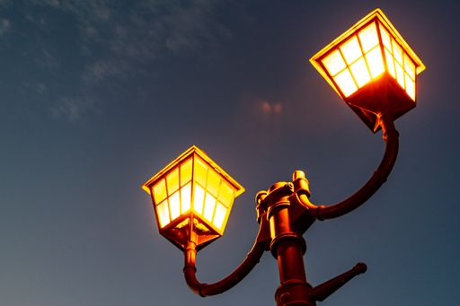 A low angle shot of two street lanterns at night against the sky