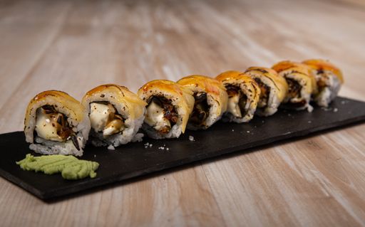 A Japanese sushi board, goat cheese uramaki on wooden background